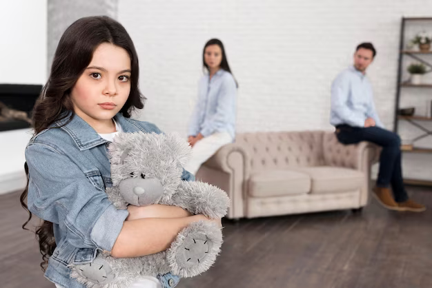 Girl holding a toy against the background of her parents