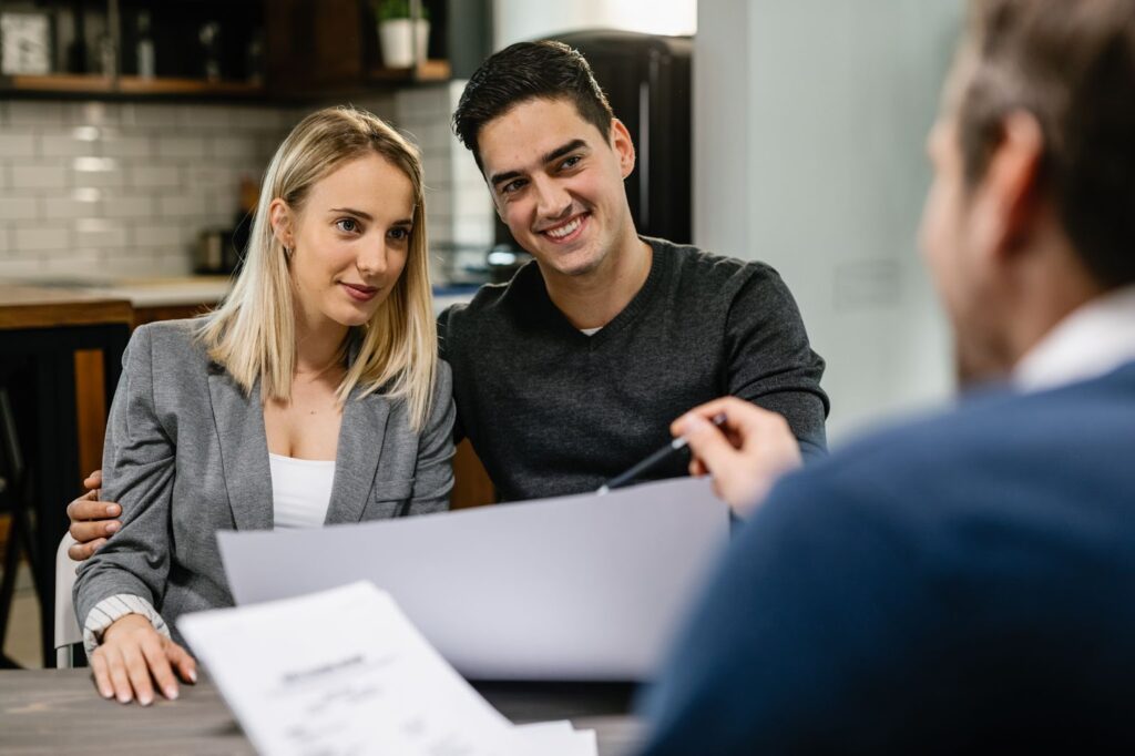 Young smiling couple having a meeting with an agent