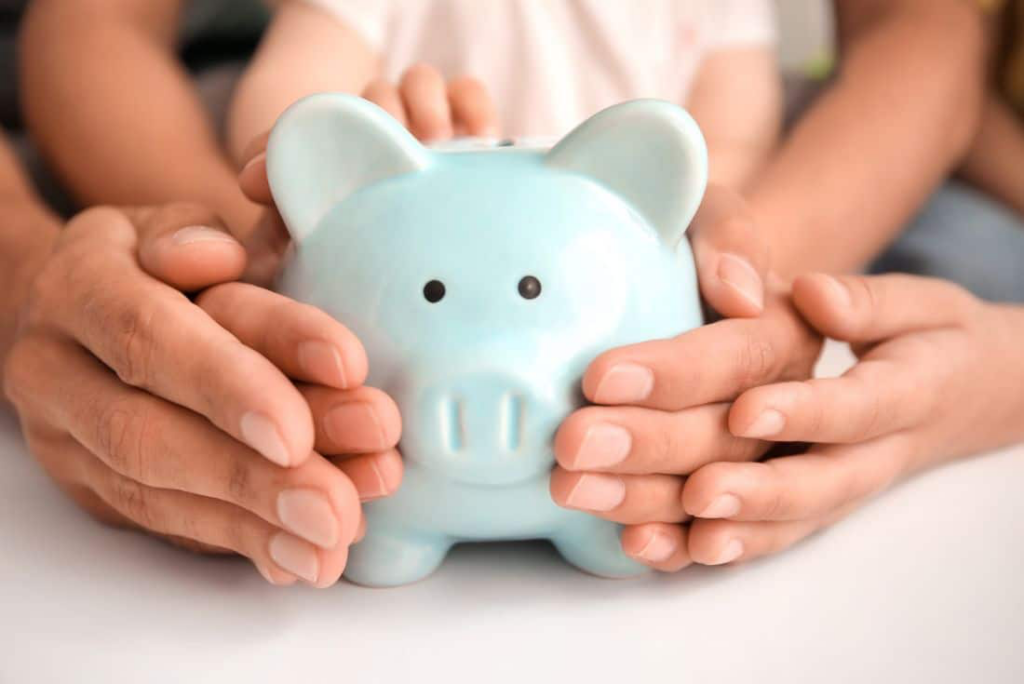 Family hands holding a piggy bank