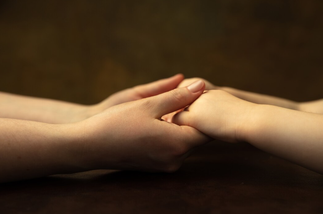 two hands holding each other on a black background