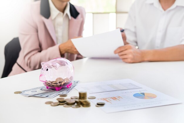 A man and a girl compose a document near the coins