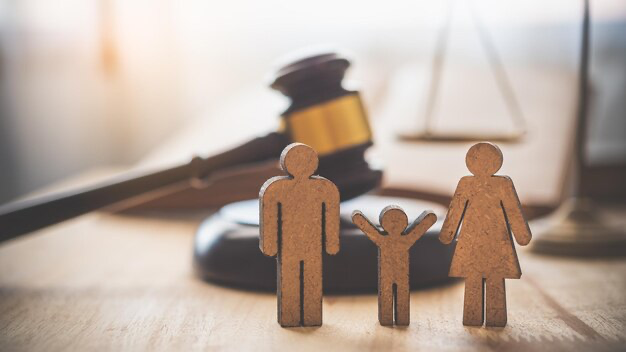 Figures in the form of a family against the background of a court gavel